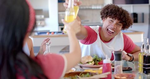 Friends Gathering for Burgers and Drinks in Kitchen Celebration