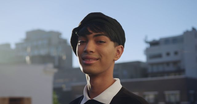 Young man stands confidently outdoors with a cityscape in the background. Ideal for use in campaigns promoting urban lifestyles, youth empowerment, fashion, and self-confidence themes.