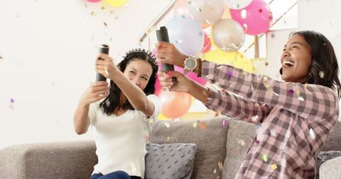 Joyful women celebrating with confetti and balloons