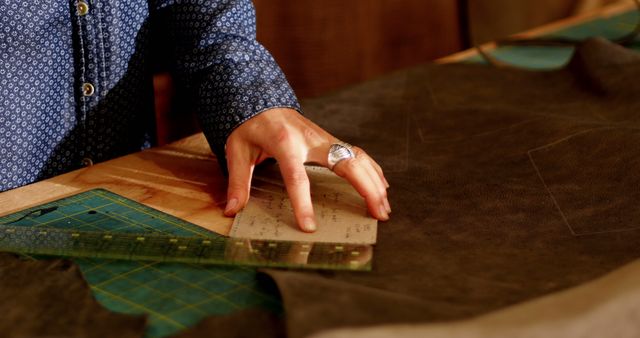 Craftswoman measuring leather with scale in workshop