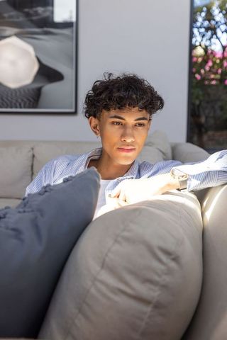 Contemplative Young Man Relaxing on Sofa in Modern Living Room