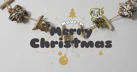 Merry Christmas Typography Over Pinecone Garland with Gold Ornaments Minimal Flatlay