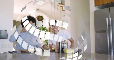 Two friends chatting and laughing at modern marble kitchen island during casual breakfast