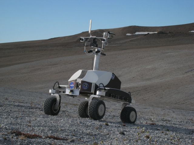 Haughton-Mars Project: - Photo credit to Matt Deans (NASA)  K-10 Rover 'Black' driving on 'Drill Hill at Haughton Creater Devon Island, Nunavut, in the Canadian high arctic. Which lies in the 'frost rubble zone' of the Earth, i.e., in a polar desert environment and is the only crater known to lie in such an environment. Beginning in 1997, the crater and its surroundings are studied as a promising Mars analog by the NASA-led Haughton-Mars Project.  (photo reference IMG_1278.JPG)
