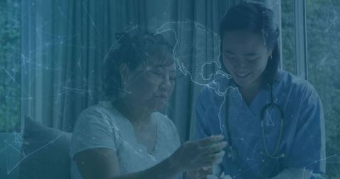 Korean nurse assisting senior patient at home reviewing medication with digital overlay