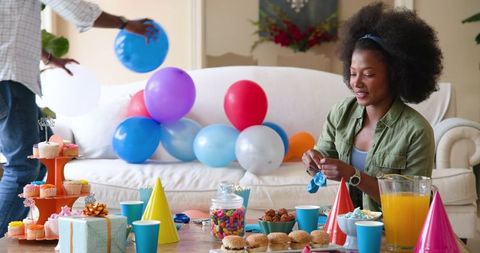 Family Preparation for Indoor Birthday Celebration with Colorful Decorations