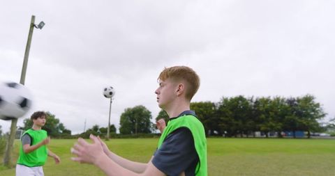 Teen soccer players practicing passing techniques on field