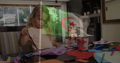 Girl creating art at home with displayed algerian flag