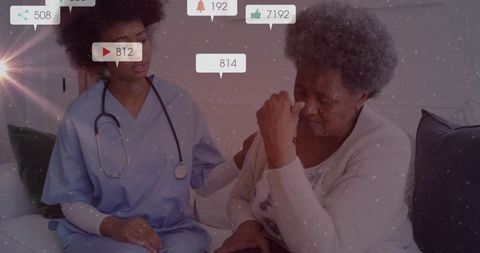 Compassionate Nurse Comforting Senior Woman on Couch with Stethoscope Visible