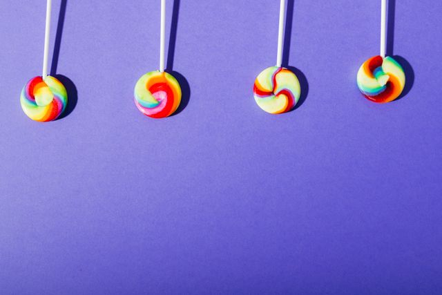 Colorful Swirl Lollipops in a Row on Blue Background - Download Free Stock Photos Pikwizard.com