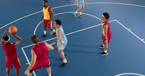 Diverse male basketball players competing on indoor court