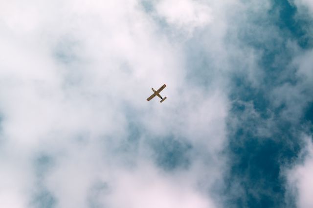 This stock photo of a small propeller plane flying through a cloudy sky is perfect for conveying themes of travel, freedom, and exploration. Ideal for use in travel blogs, aviation websites, or any content related to air transportation, adventure, and the open skies. The image's serene composition also suits backgrounds for inspirational quotes or motivational materials.