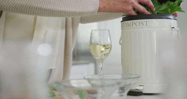 A senior woman enjoys retirement by composting and sipping wine in her kitchen. - Download Free Stock Photos Pikwizard.com