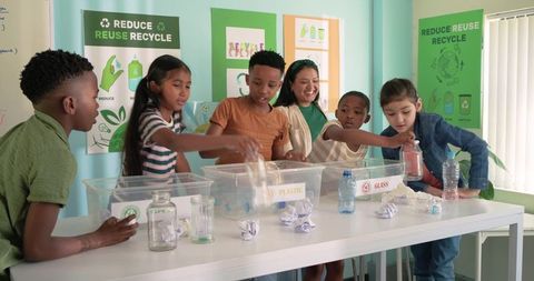 Elementary Students Sorting Recycling with African American Teacher Leading Sustainability