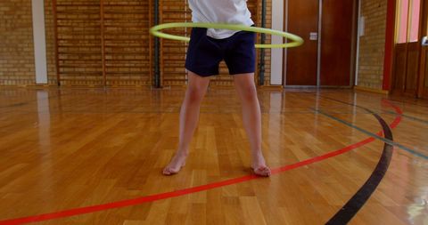 Child Enjoying Hula Hoop in School Gymnasium
