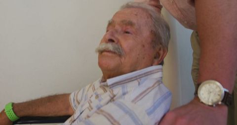 Doctor Assisting Elderly Man in Wheelchair at Retirement Home