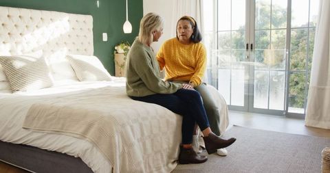 Female Friends in Cozy Bedroom Sharing Warm Companionship