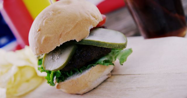 Close-Up of Juicy Hamburger with Pickles on Wooden Surface - Download Free Stock Images Pikwizard.com