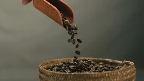 Pouring Fresh Coffee Beans Into Rustic Woven Basket in Slow Motion