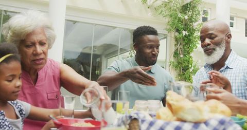 Family Enjoying Breakfast Outdoors in Sunny Garden