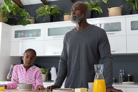 African american father and daughter sharing cozy kitchen breakfast with indoor plants