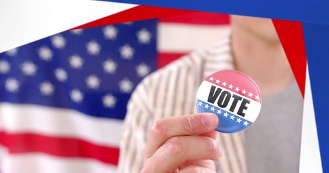Caucasian man holding vote badge with usa flag background