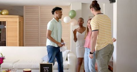 Friends Celebrating New Job with Balloons in Living Room