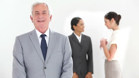 Confident Businessman in Suit with Coworkers in Discussion