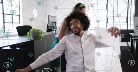 Leaning curly man holding large sheet in modern open office with ai network overlay