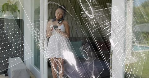 Woman standing using smartphone in patio doorway wearing white dress, headphones, hud overlay