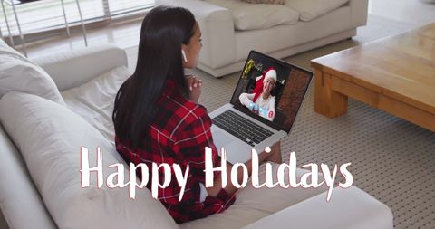 Woman video calling with festive message on screen during holidays