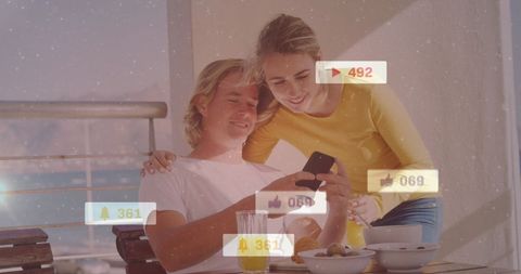 Smiling Couple Engaging with Social Media on Smartphone at Cafe