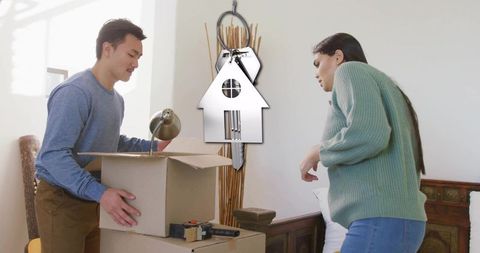Couple packing and moving into new home with keys graphic and cardboard boxes