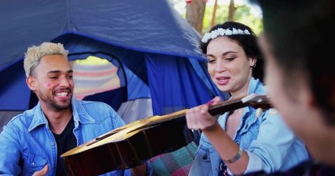 Friends Enjoy Camping with Guitar at Forest Festival