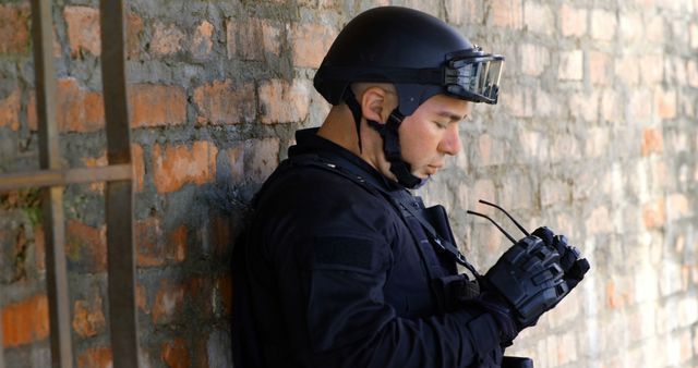 Swat Team Officer Resting Against Brick Wall - Download Free Stock Images Pikwizard.com