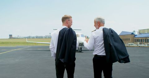 Caucasian Pilots Conversing on Tarmac Before Flight - Download Free Stock Images Pikwizard.com
