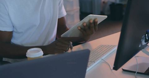 Young professional using tablet and computer in modern workspace