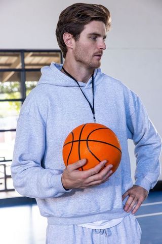 Basketball Coach Holding Ball on Indoor Gym Court