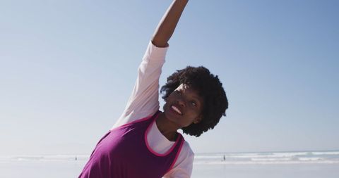 Woman Practicing Yoga by the Sea on Sunny Day