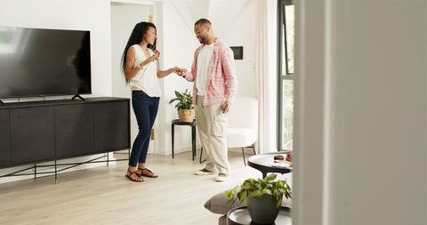 Engaged couple celebrating with photos and rose at home