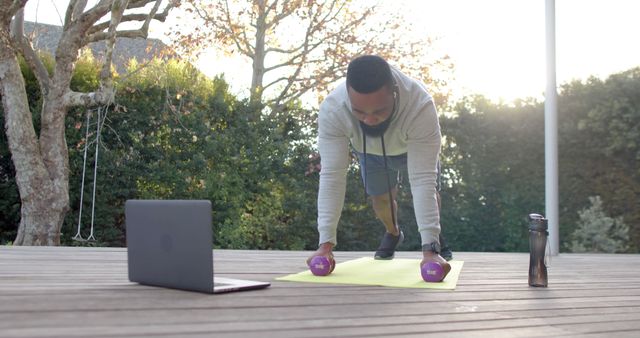 Man Practicing Outdoor Home Workout with Dumbbells and Laptop - Download Free Stock Images Pikwizard.com