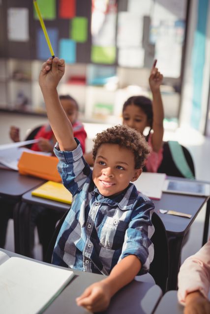 Schoolchildren actively participating in a classroom setting by raising their hands. Ideal for educational materials, school brochures, teaching resources, and articles on student engagement and classroom dynamics.