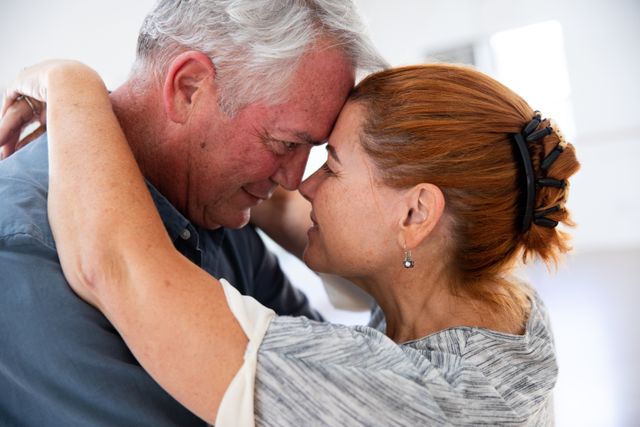 This image captures a happy senior couple embracing and smiling at each other before their ballroom dancing class. It can be used for promoting senior activities, dance classes, romantic relationships, and healthy lifestyles among the elderly. Ideal for websites, brochures, and advertisements focusing on senior living, wellness, and community engagement.