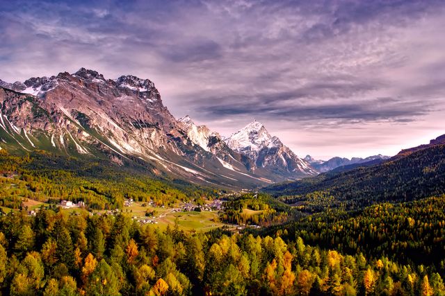 This stunning image captures a mountainous landscape with a small village nestled among autumnal trees. Ideal for nature-themed promotions, travel brochures, posters, or as desktop wallpapers. The picturesque quality conveys tranquility and the beauty of rural settings, making it perfect for environmental campaigns or relaxation-themed content.