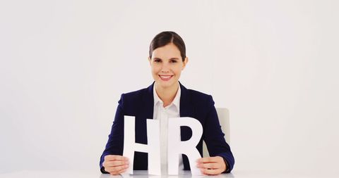 Smiling Businesswoman Holding HR Letters Illustrating Human Resources Concept - Download Free Stock Images Pikwizard.com