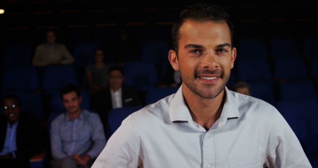 Confident Man Smiling in Auditorium with Audience - Download Free Stock Images Pikwizard.com