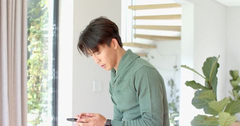 Man Engaging with Smartphone in Minimalist Urban Interior