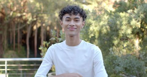 Young Man Relaxing on Balcony Overlooking Lush Forest