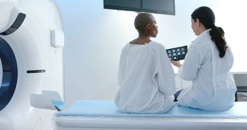 African american patient and doctor reviewing ct scans for diagnostic consultation