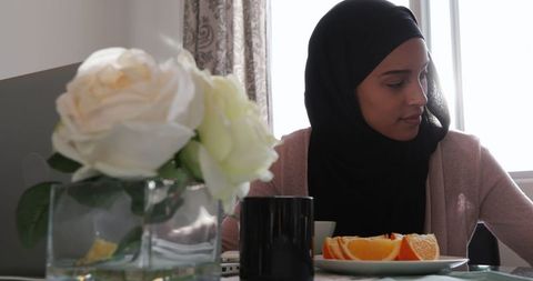 Mother with hijab multitasking breakfast work from home